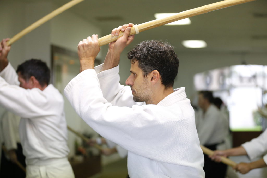 man practicing aikido weapons